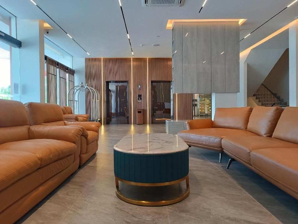 a living room with couches and a coffee table at J HOTEL in Kampong Kiulap