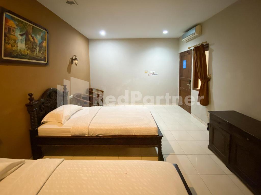 Postel nebo postele na pokoji v ubytování Istana Griya 2 Hotel Solo RedPartner