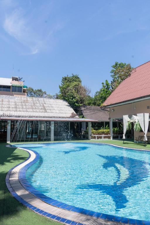 a large swimming pool with a house and a building at Banna Resort in Ban Khlong Kadon (1)
