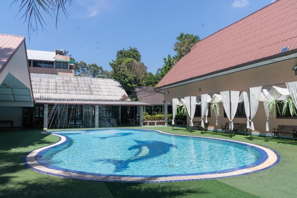 - une piscine dans une cour à côté d'un bâtiment dans l'établissement Banna Resort, à Ban Na