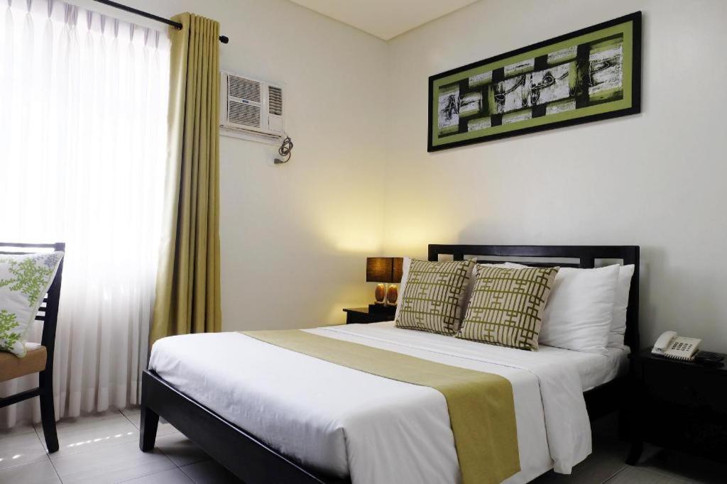- une chambre avec un grand lit et un téléphone dans l'établissement Hari Royale Suites, à Davao