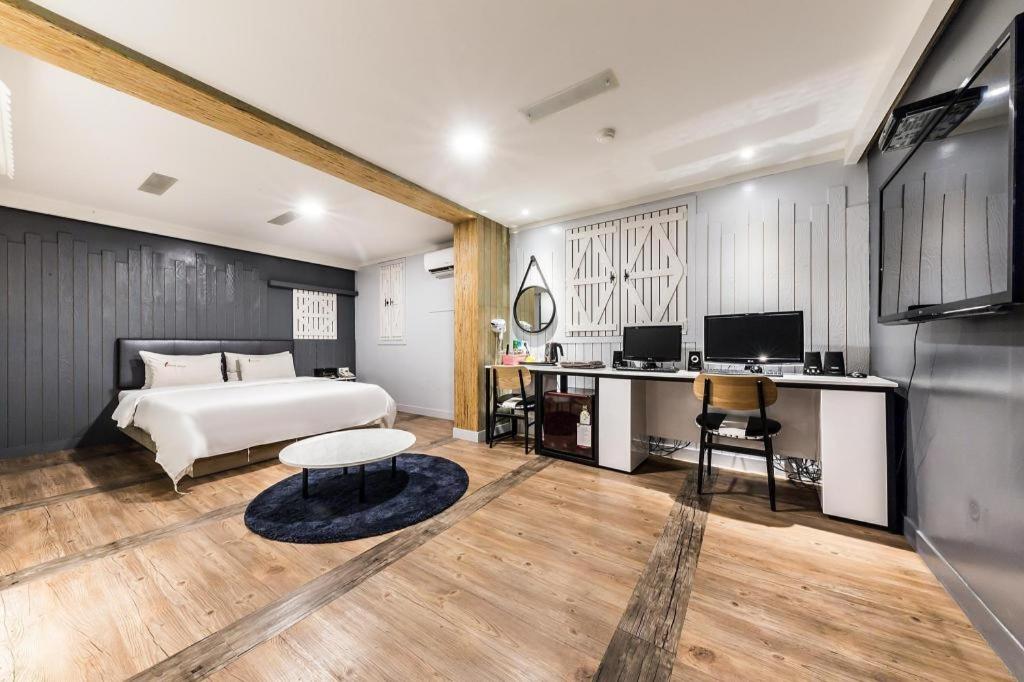 a bedroom with a bed and a desk with a computer at Sinchon A plus in Seoul