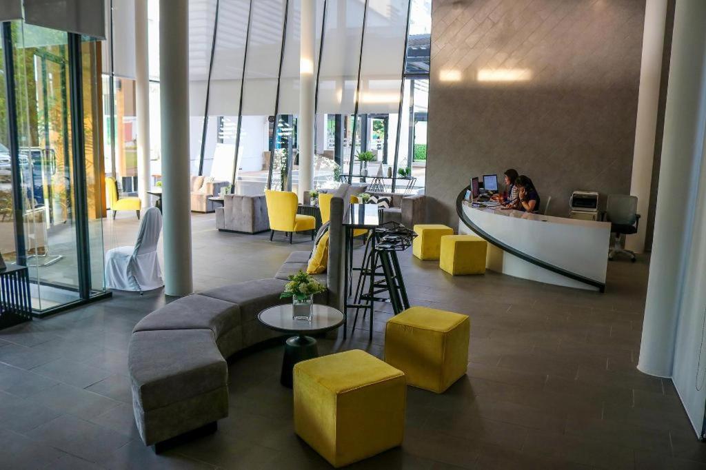 a lobby with yellow stools and a counter in a building at DLUXX THAMMASAT in Ban Bang Phut (3)