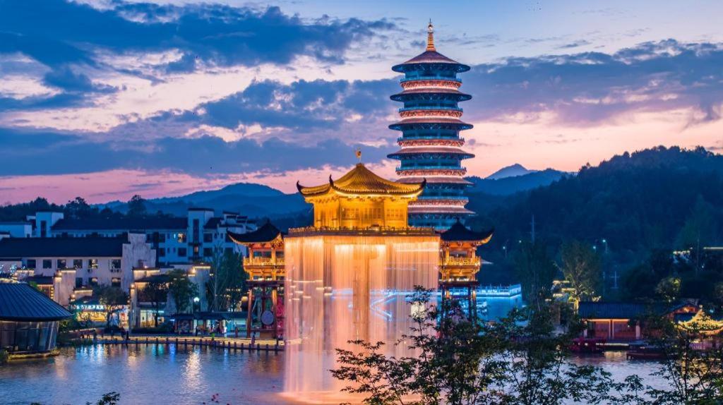 a lit up pagoda in the middle of a city at Wuyuan Wunvzhou Wuxiandao Luxury Hotel in Wuyuan