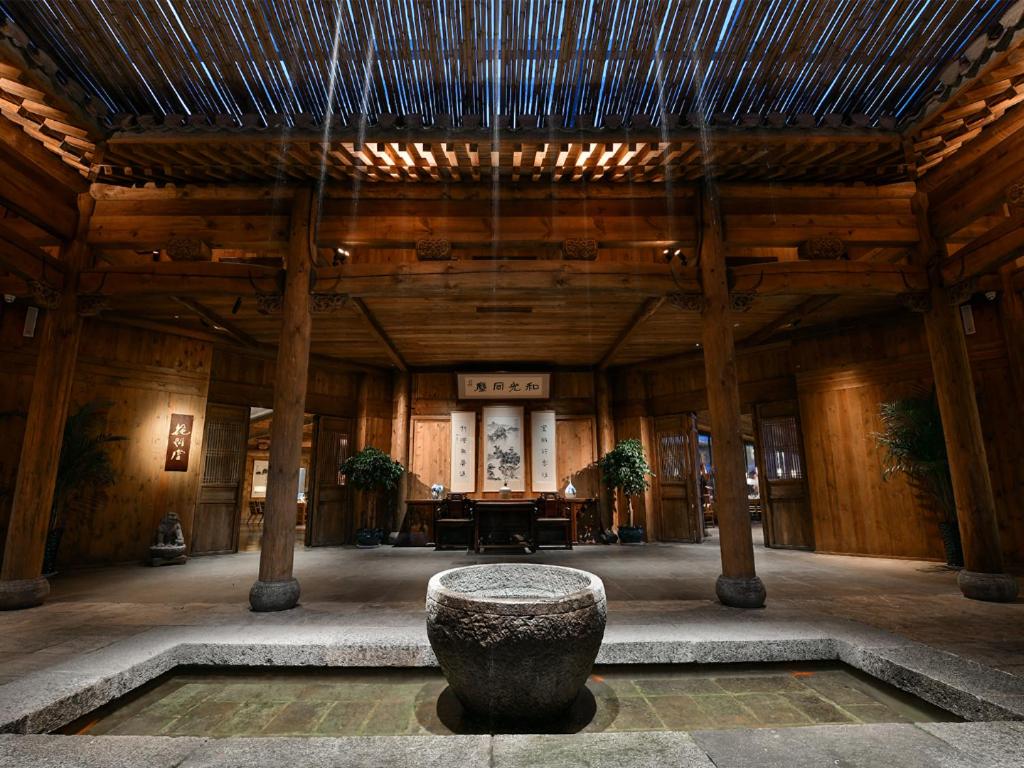 ein großes Zimmer mit einer Steinschale in der Mitte eines Gebäudes in der Unterkunft Blossom House Jinan Shunlu in Jinan