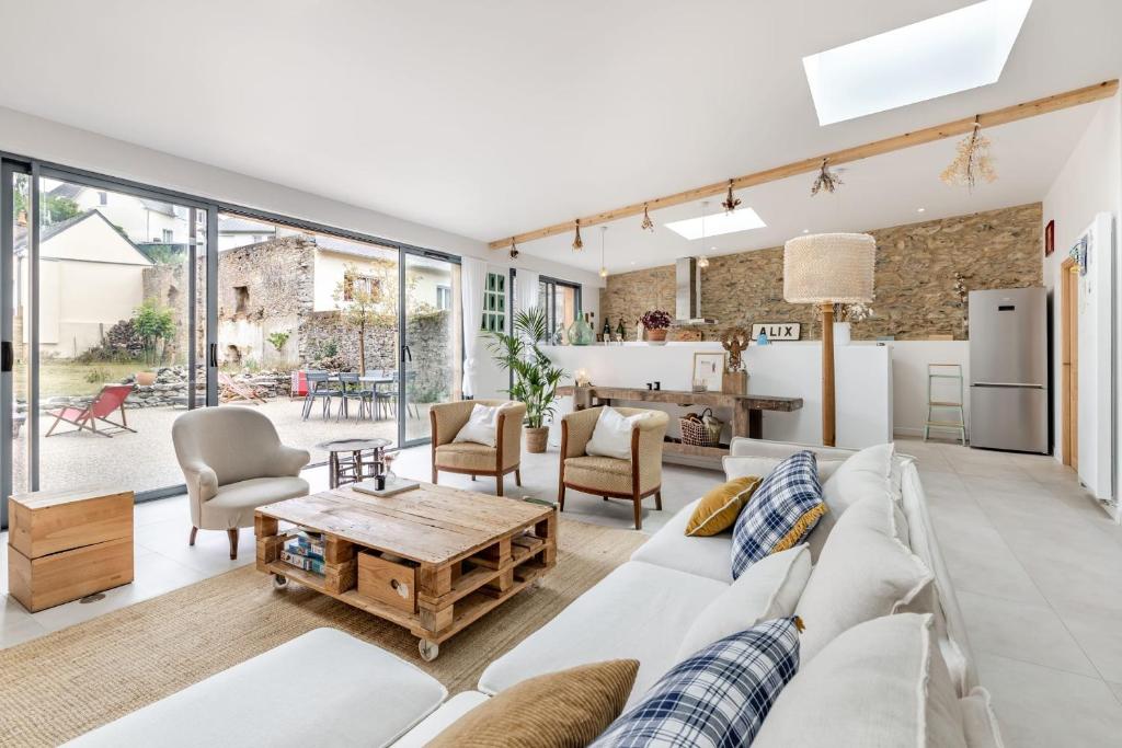 La Familia - Maison chaleureuse في لافال: غرفة معيشة مع أريكة بيضاء وطاولة