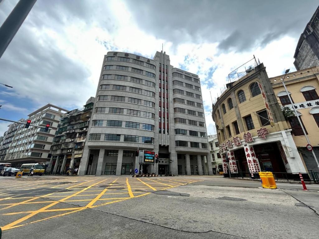 una calle de la ciudad con dos edificios altos y un semáforo en Grande Hotel Macau en Macao