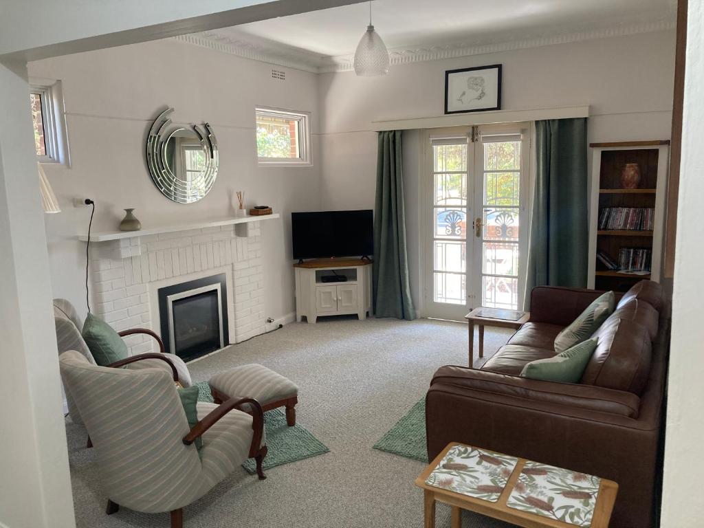 a living room with a couch and a fireplace at Herbert Cottage in Tumut