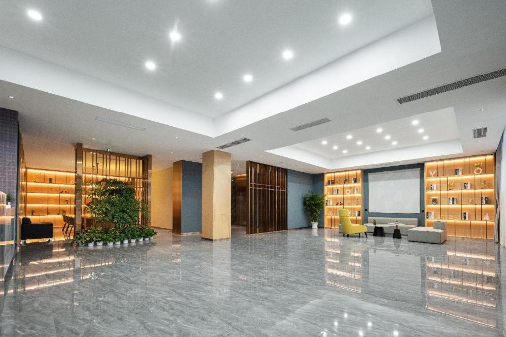 a lobby with a large room with many shelves at Borrman Hotel Wuhan Optics Valley Fozuling Gaoxin 4th Road in Liufangling
