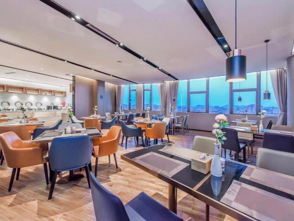 貴陽的住宿－Echarm Hotel Guiyang Zhongshan West Road Metro Station，餐厅设有桌椅和窗户。