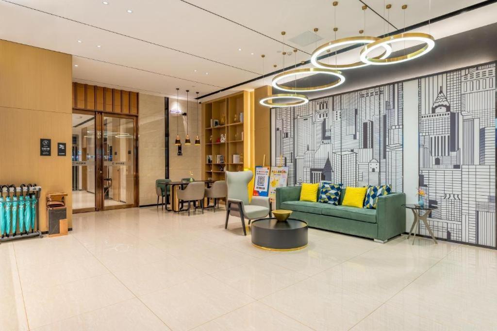 a living room with a green couch and a table at City Comfort Inn Wuhan Dongxihu Tianyuan Avenue in Wuhan