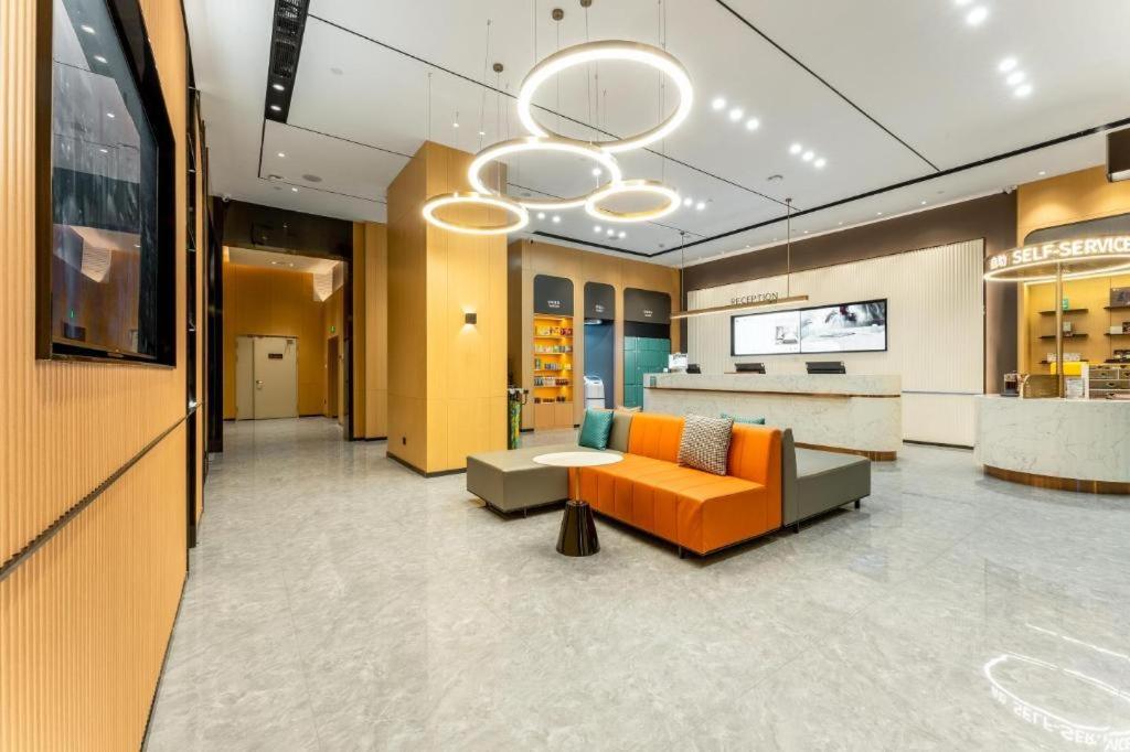 an office lobby with an orange couch and a counter at City Comfort Inn Yichang Zhongnan Road Changjiang Plaza in Baiyang