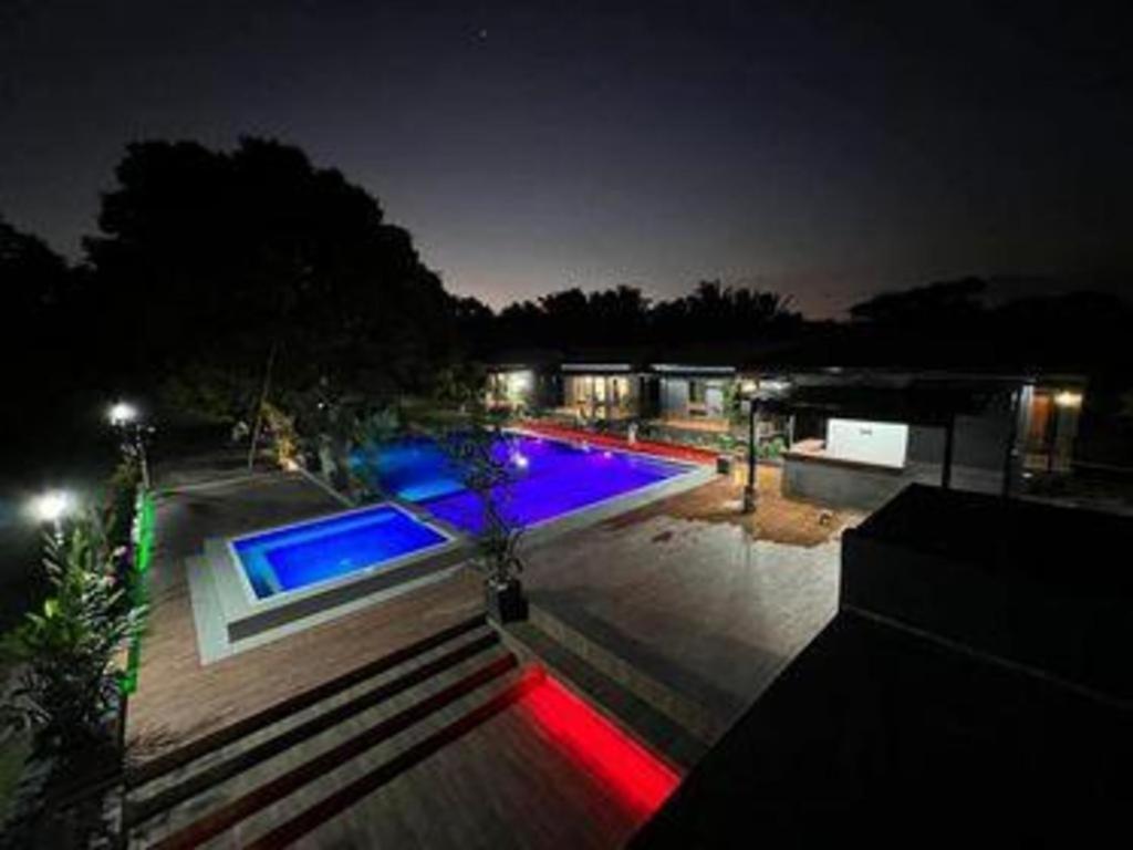 a swimming pool at night with red and blue lights at Balai Angelica - Nature Farm & Resort in Pagsanjan