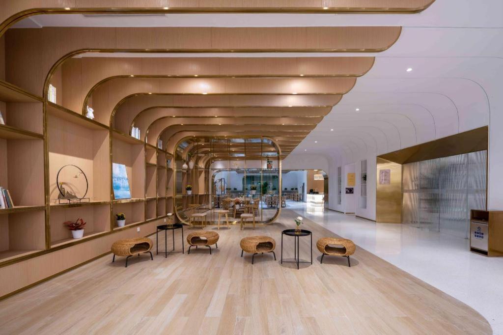 a lobby with chairs and tables in a building at 杭州火车东站钱唐嘉客酒店 in Wuhang