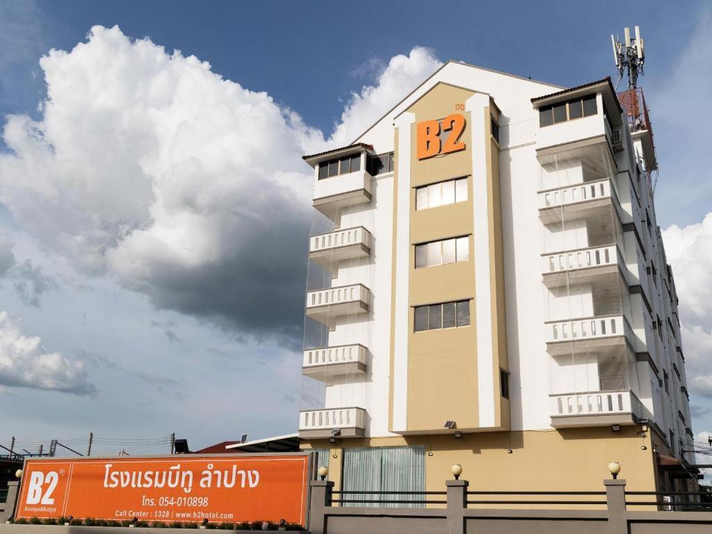 um edifício com um sinal laranja na lateral em B2 Lampang Boutique & Budget Hotel em Ban Nam Thong