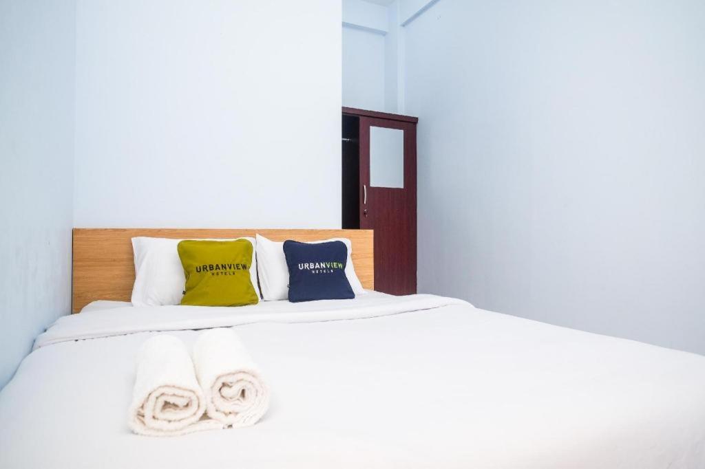 Ένα ή περισσότερα κρεβάτια σε δωμάτιο στο Urbanview Syariah Wisma Nabil Solo