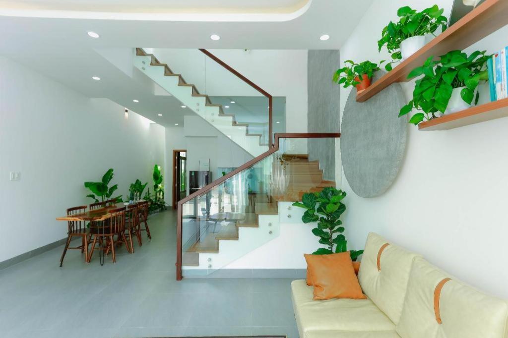 a living room with a couch and a staircase at Nha Trong Pho - Green House in Buôn Ðũng