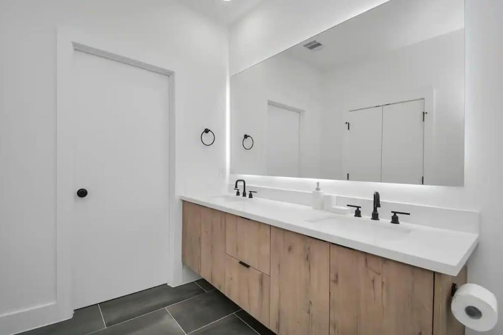 a bathroom with a sink and a large mirror at 6 Mins to Dwtn /12 Mins to Rodeo in Houston