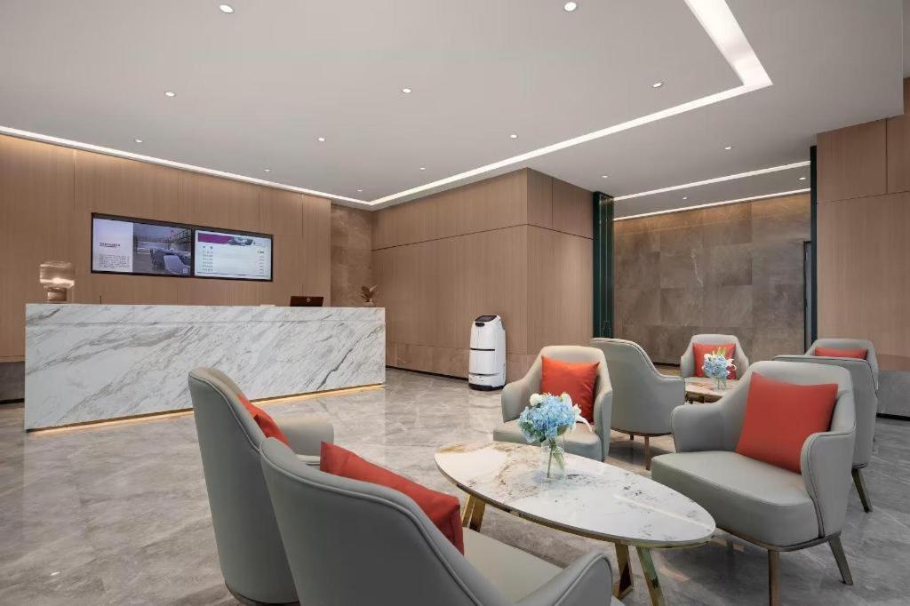 eine Lobby mit einem Wartezimmer mit Stühlen und einem Tisch in der Unterkunft Ramada Encore by Wyndham Jinan Shanghe in Shang-ho-hsien
