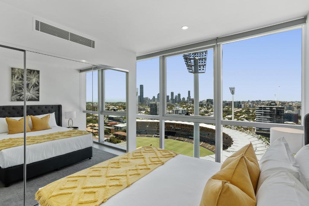 a bedroom with a bed and a large window at Executive 2-Bed with Stadium View, Great Amenities in Brisbane