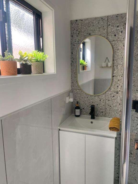 y baño con lavabo blanco y espejo. en Ange's BnB - Self Contained Unit with Ensuite, en Lyndhurst