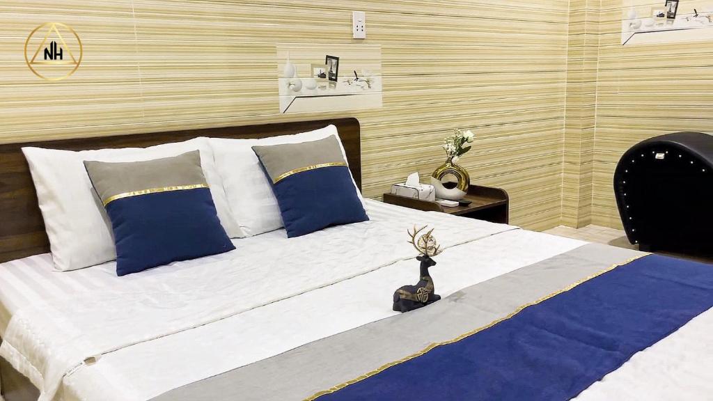 a bedroom with a large bed with blue and white pillows at Gia Hân Hotel Bình Tân in Ho Chi Minh City