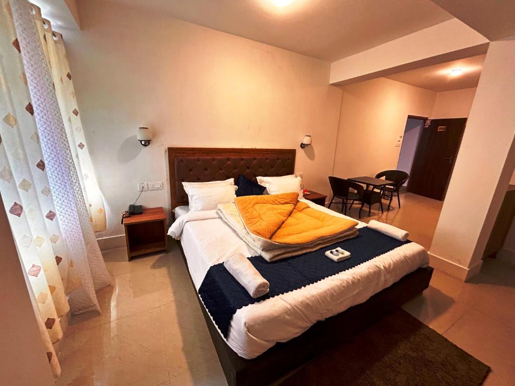 a bedroom with a bed and a table with chairs at DISHA SILVER PEAK Hotel in Pelling