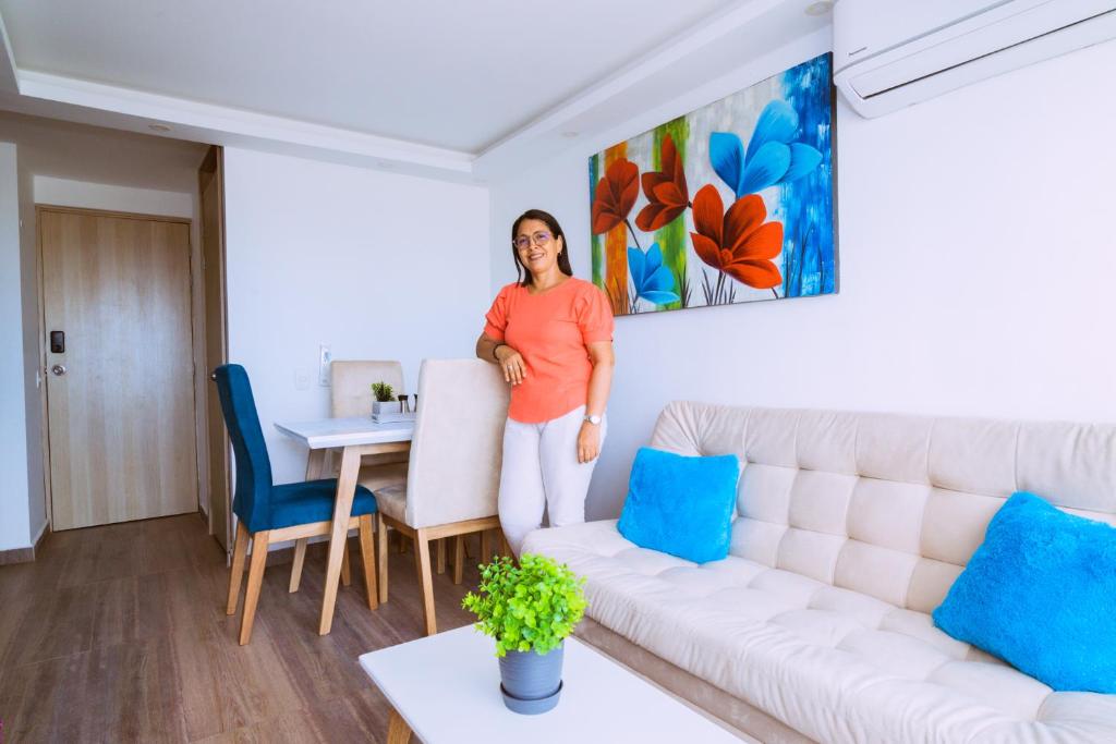 uma mulher numa sala com um sofá em Apartamento El Colibri Cartagena en torre PRIMI em Cartagena das Índias