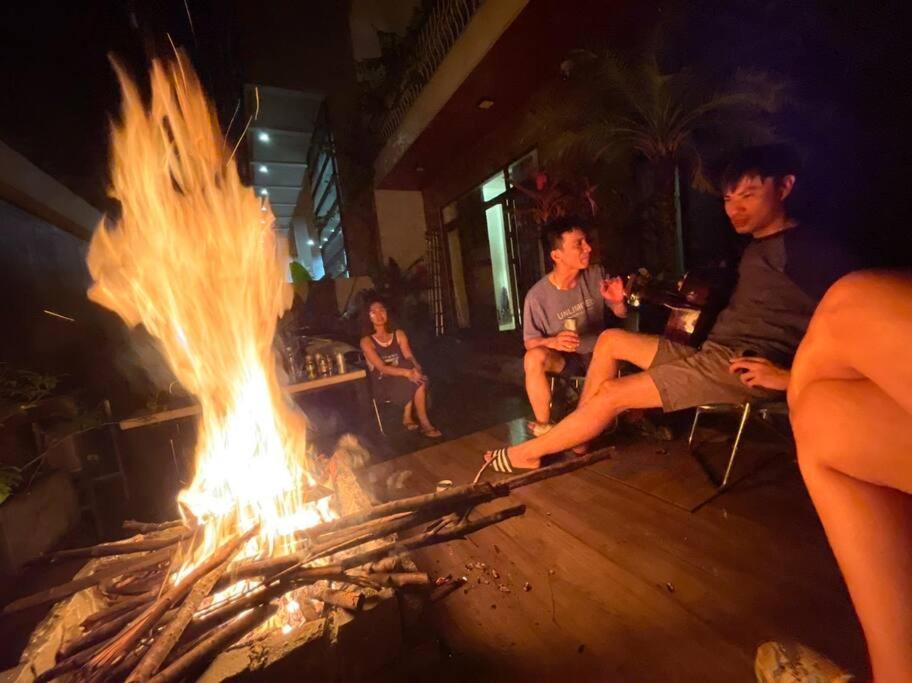 a group of people sitting around a large fire at Sol Villa 4BR, Pool, Near Han River, Camp Fire in Da Nang