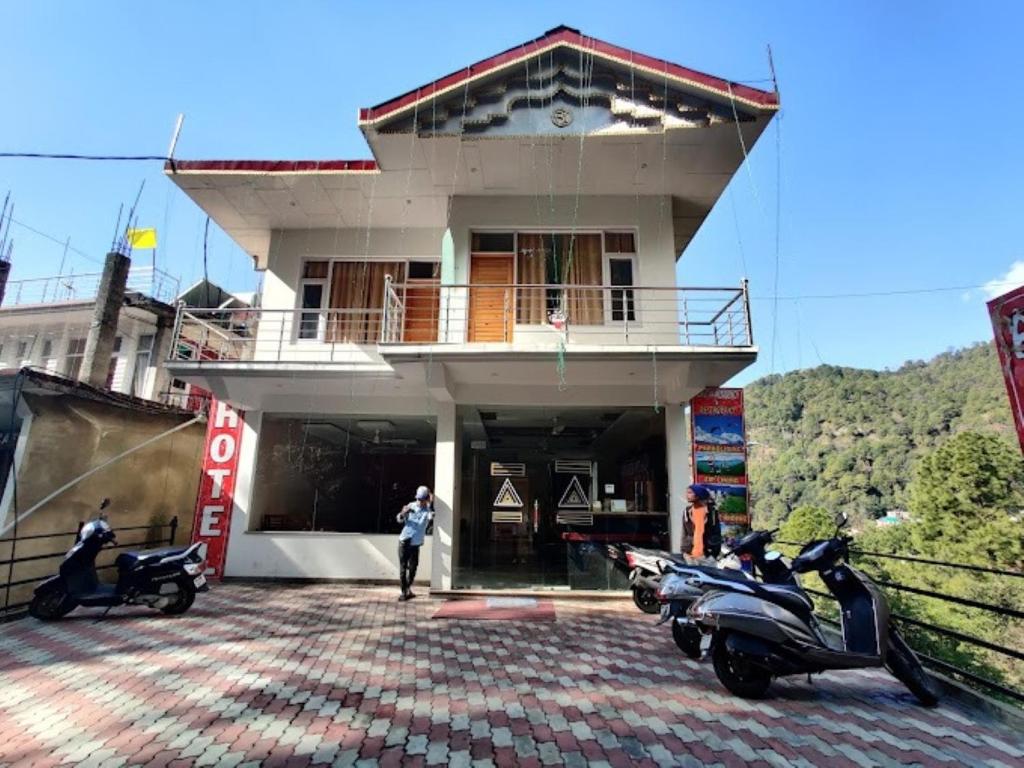 a building with motorcycles parked in front of it at Agastya Residency Dharamshala in Dharamshala