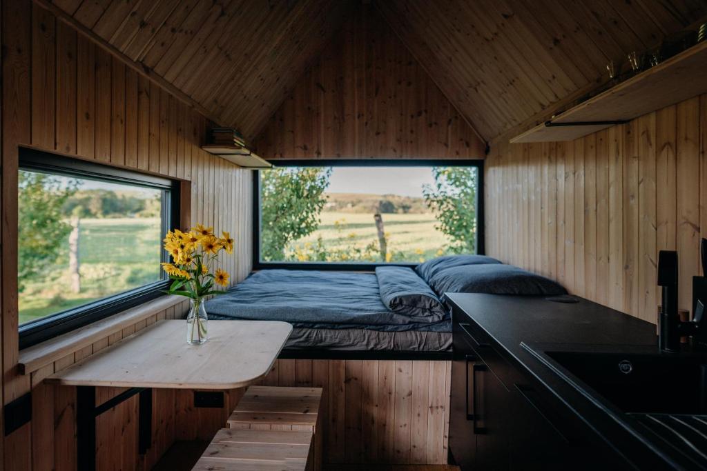 Bett in einem Zimmer mit einem Tisch und einem Fenster in der Unterkunft AIVA Glamping in Partizánske