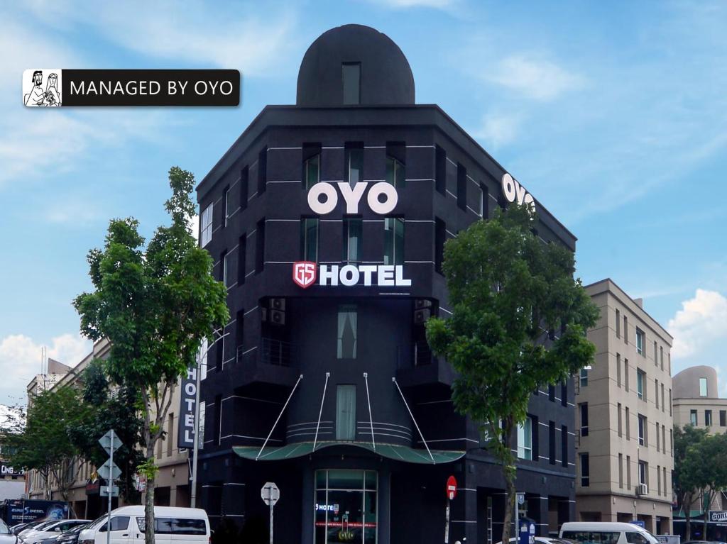 Super OYO GS Hotels Near Strand Mall في كوتا دامانسارا: مبنى أسود مع علامة فندق ovo عليه
