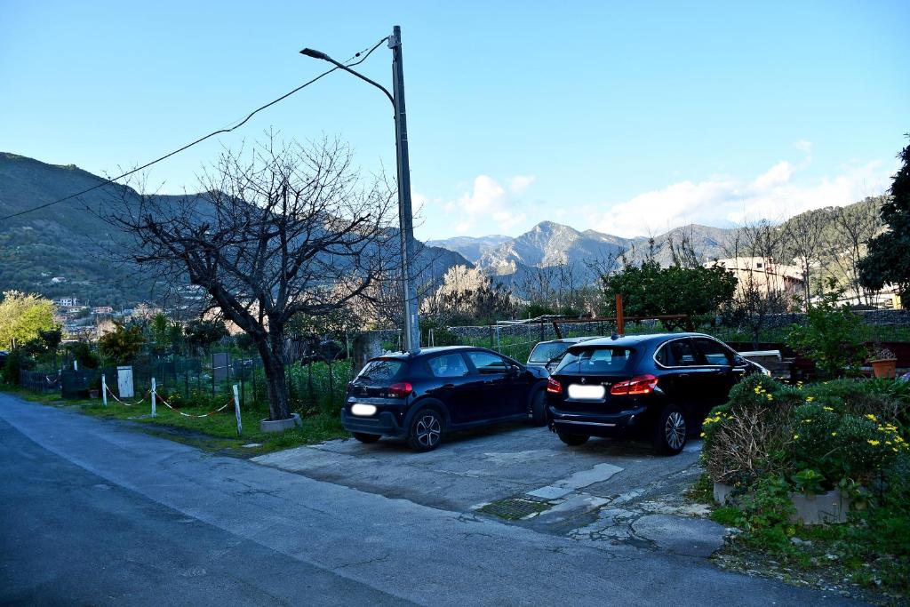 zwei Autos auf einem Parkplatz mit Bergen im Hintergrund geparkt in der Unterkunft CASA RINA in Ventimiglia