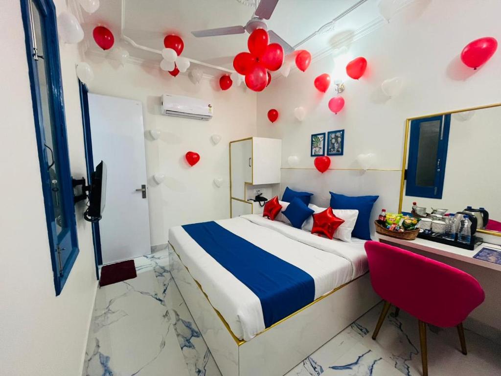 Schlafzimmer mit einem Bett mit roten Ballons an der Decke in der Unterkunft The Host in Amritsar