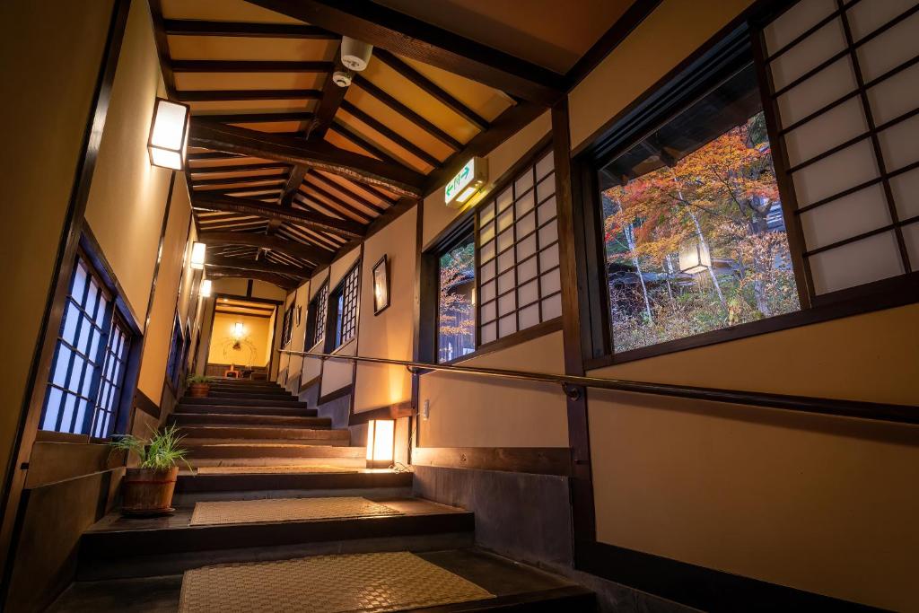a hallway of a building with stairs and windows at Konashi No Yu Sasaya in Matsumoto