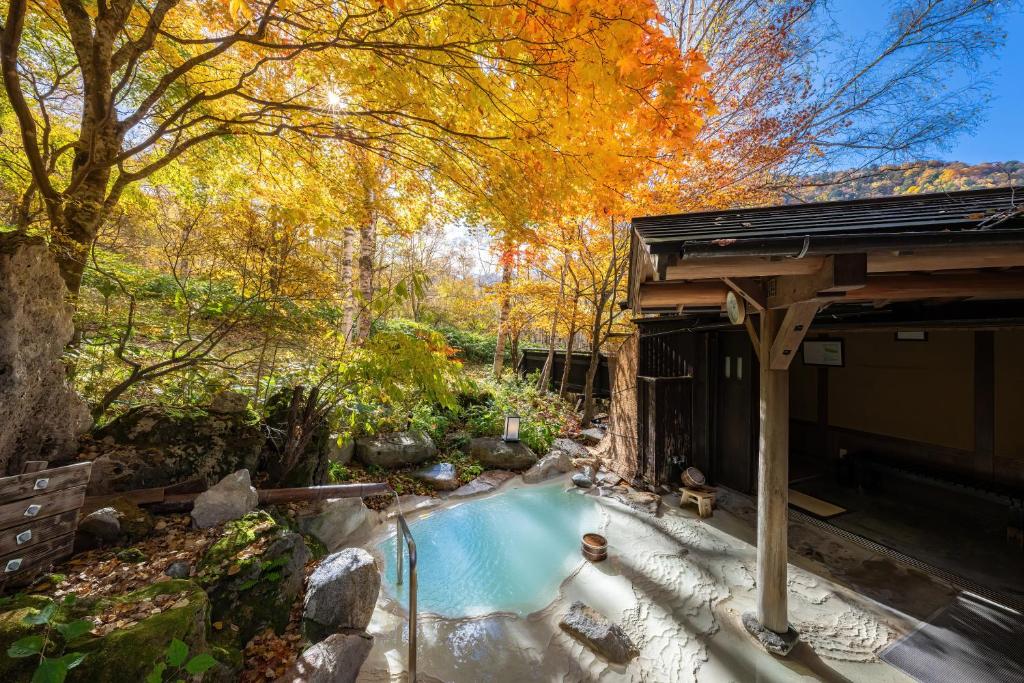 a swimming pool in the middle of a garden at Konashi No Yu Sasaya in Matsumoto