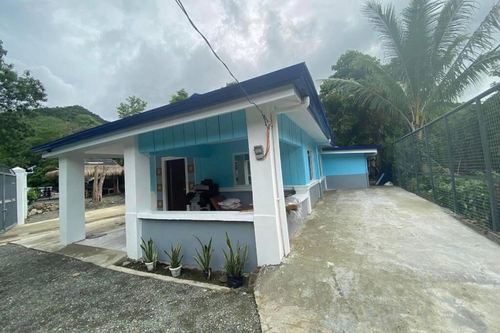 a small blue house with a blue roof at Riverwalk Transient House in Bongabon