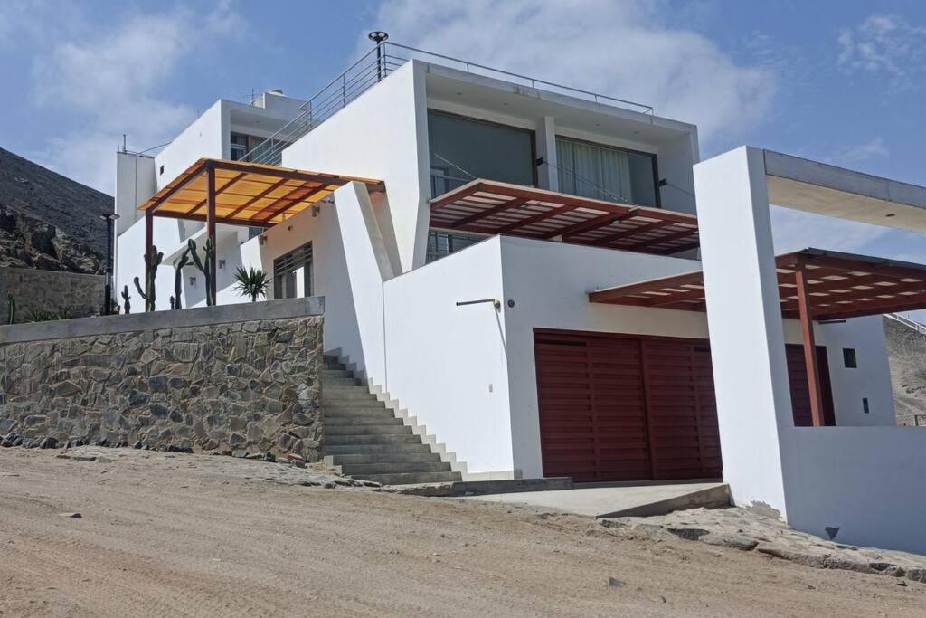 a white house with stairs and a garage at Casa de Playa en Tortugas - Beach House Tortugas in Tortuga