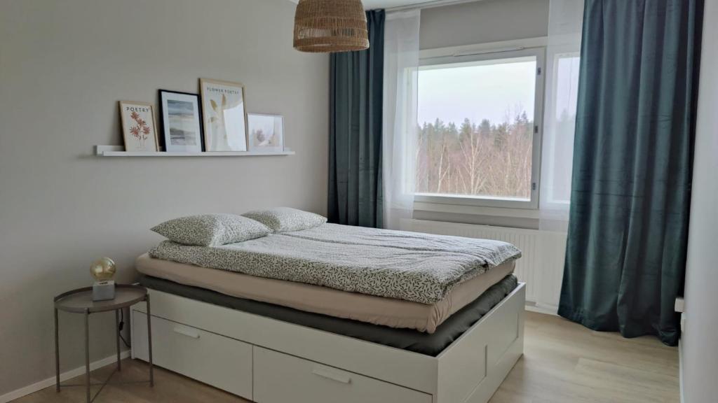 Bett in einem Zimmer mit Fenster in der Unterkunft Green Getaway - near Helsinki Vantaa Airport, top-floor, free parking & wifi in Vantaa