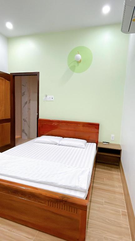 um quarto com uma cama grande e lençóis brancos em Nhà Nghỉ Thảo Tiên em Xóm Tràm Cửa