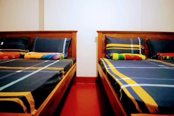 two beds sitting next to each other in a room at Black And White Elkaduwa Guest House in Elkaduwa
