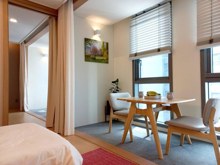 a bedroom with a table and chairs and a bed at Mansion216, Haeundae Beach new residence in Busan