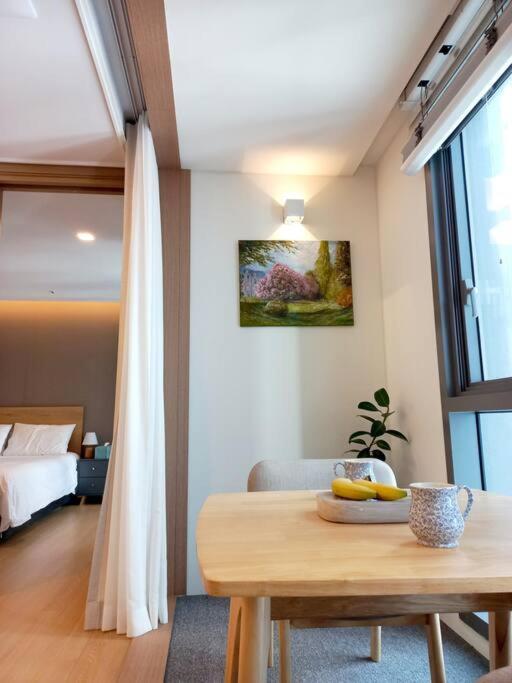 a room with a table and a bedroom with a bed at 해운대 엘본 # Haeundae station 3min# sea 3min# high floor view# luggage storage# flexible checkin& out# family in Busan