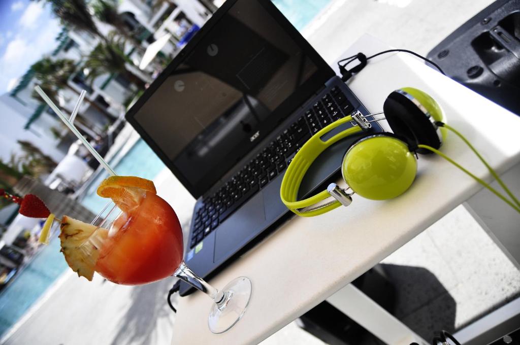 a laptop computer sitting on a table with headphones at Barceló Teguise Beach - Adults Only in Costa Teguise