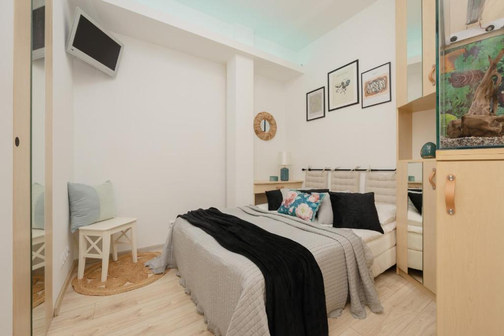 a white bedroom with a bed and a couch at Stars Apartment Andersa by Renters in Warsaw