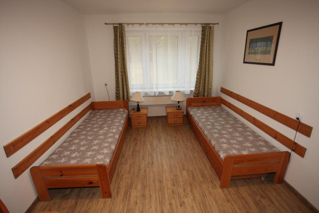 a small room with two beds and a window at Leśniczówka Wigierskiego Parku Narodowego w Maćkowej Rudzie in Krasnopol