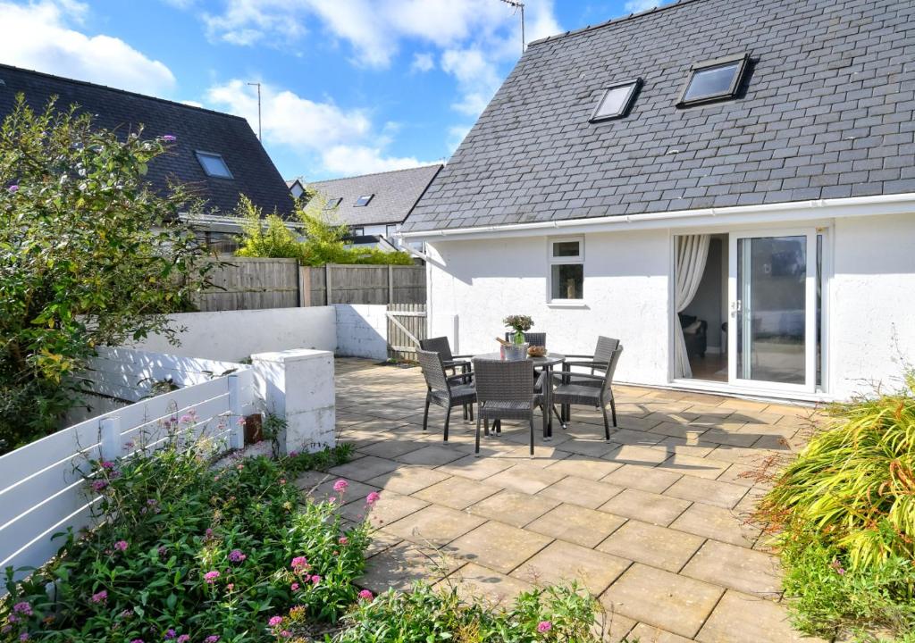 a patio with a table and chairs in a house at 243 Cae Du in Abersoch