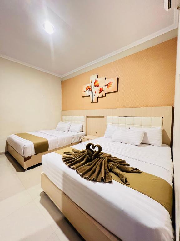 Postel nebo postele na pokoji v ubytování Ayuri Hotel Malioboro