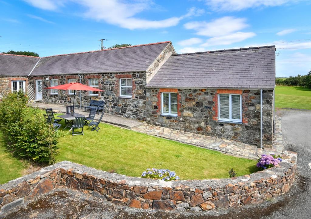 an image of a stone house with a garden at Y Stabl in Abersoch