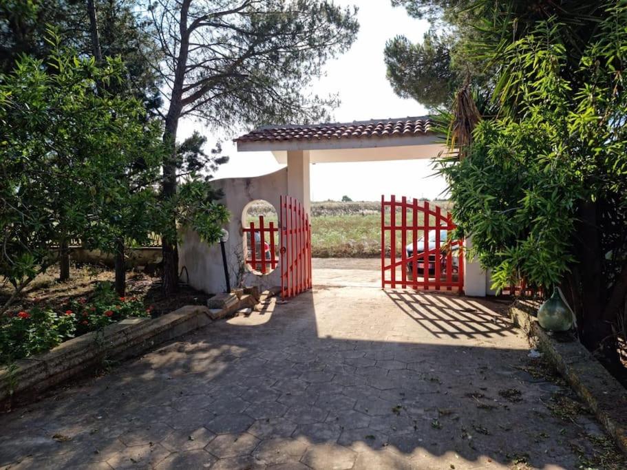 un portail rouge devant un garage dans l'établissement Casedda andrea, à Sternatia
